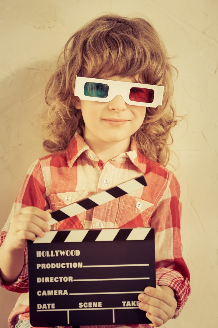 Kid holding clapper board in hands. Cinema concept. Retro style